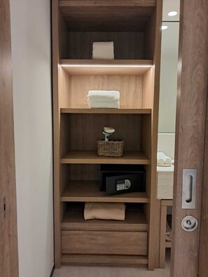 Un armari de fusta amb múltiples prestatges, una cistella penjant i un dispositiu electrònic negre.