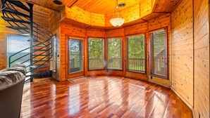 Une cabane dotée d’un escalier en colimaçon, de grandes fenêtres et d’un lustre.