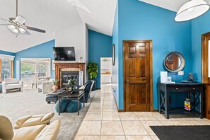 A living room with a fireplace, a television, and a door.