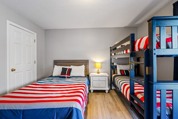 A room with two beds, a nightstand, and a lamp. - Livin` the Dream: Lakefront, Dock, Firepit, 16 (LaFollette)