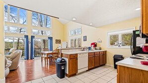 A spacious kitchen with large windows, a dining area, and a view of the outdoors. - Livin` the Dream: Lakefront, Dock, Firepit, 16 (LaFollette)