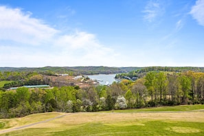 Vista panorámica de un lago con carretera, edificios y árboles.