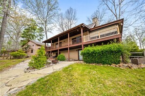 Une maison en bois à deux étages, dotée d’un porche couvert et d’un chemin de pierre menant à l’entrée.