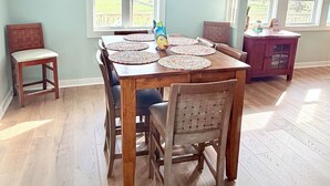 A dining room with a wooden table, chairs, and a ceiling fan. - Water’s Edge at Randall’s - Cottage Overlooking the Intracoastal Waterway (Shallotte)