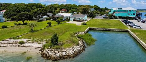 A waterfront property with a swimming pool, a dock, and a parking area.