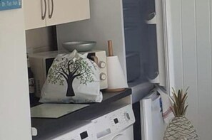 Una cocina con microondas, tostadora y una bolsa con diseño de árbol en la encimera.