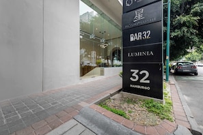 A modern building with a glass facade and a sign indicating 'BAR 32 LUMENIA 32 HAMBURG'. - Capitalia Juarez | Central Studio + Balcony & Gym (Ciudad de México)