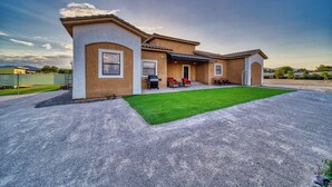Ein zweistöckiges Haus mit Terrasse, Rasen und Garage.