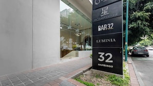 Een modern gebouw met een glazen gevel en een bord waarop staat 'BAR 32 LUMENIA 32 HAMBURG'.
