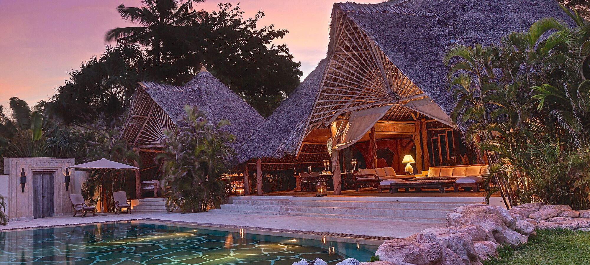 Un complexe hôtelier doté de villas aux toits de chaume, d’une piscine et d’espaces de détente en plein air.