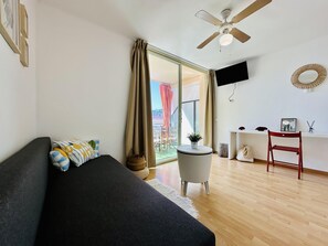 A modern room with a bed, a desk, a chair, a ceiling fan, and a TV mounted on the wall. - Gigi Loft CostaBravaSi - Sea views, beach (Santa Cristina d'Aro)