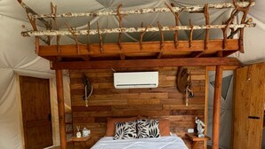 A tented room with a bed, wooden headboard, and a ceiling structure. - Dome in green Patagonia with view and access to the Petrohue River, Tinas Calientes. (Cochamo)