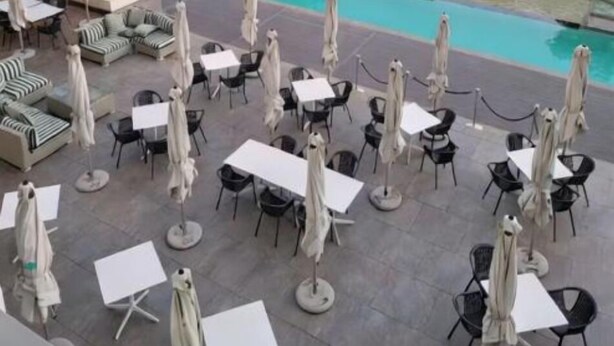Un espace piscine sur le toit, avec des sièges extérieurs et une vue sur le panorama urbain.