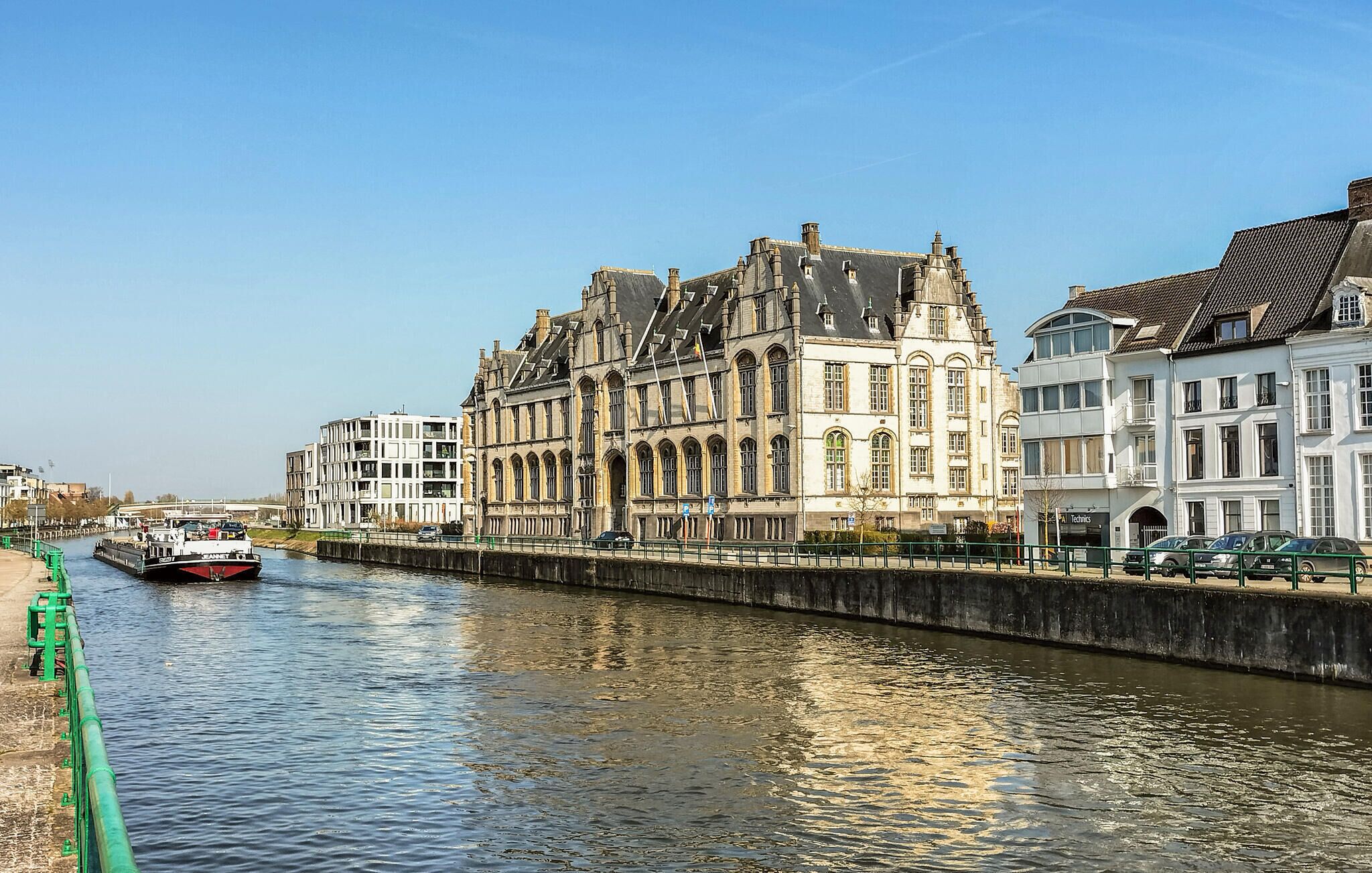 Ein Kanal mit einem historischen Gebäude und einem modernen Bauwerk.