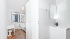 Un baño moderno con sanitarios blancos, un espejo y un inodoro.