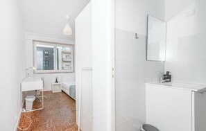 A modern bathroom with white fixtures, a mirror, and a toilet. - HOUZE Spacious Apartment near Marquês de Pombal (Lisboa)