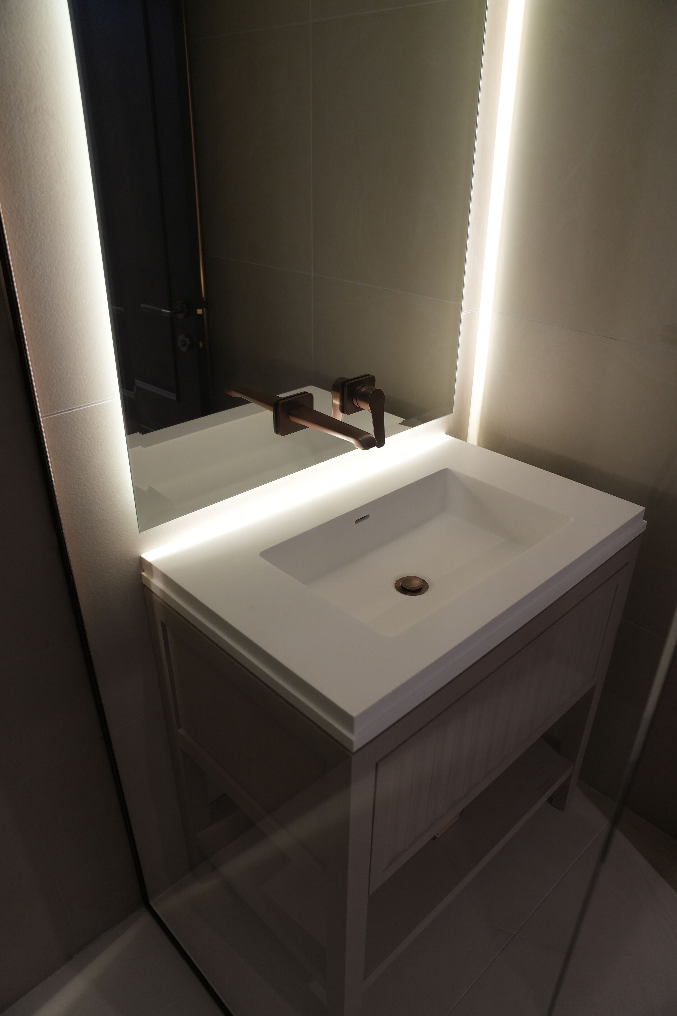 Ein modernes Badezimmer mit einem weißen Waschbecken, einem Spiegel und einer Duschkabine.