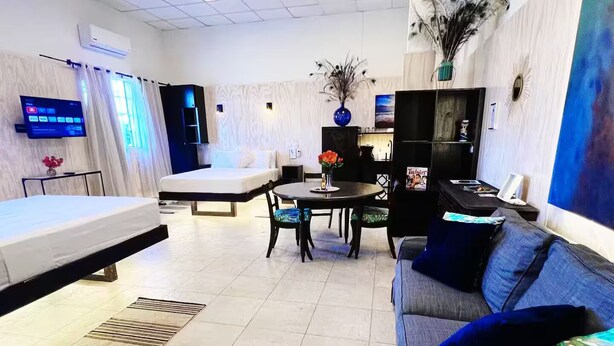 Une chambre d’hôtel moderne équipée d’un lit, d’un canapé, d’une table à manger et d’un téléviseur.