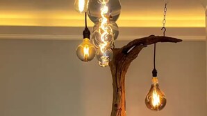 Un lustre doté de plusieurs ampoules et d’un design original en forme de branche d’arbre.