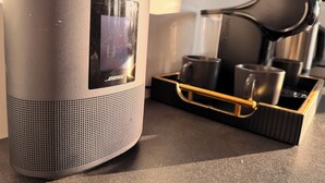 A black Bose speaker with a digital display, a tray with a coffee maker, cups, and a kettle. - Lakefront Cabin w/ Sauna & Hot Tub | Aiyana Retreat (Gauja)