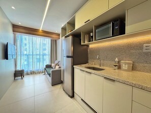 Deluxe appartement | Privékeuken | Een koelkast met diepvriezer, een microgolfoven, een kookplaat