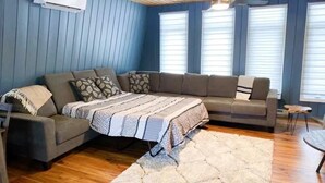 A modern living room with a sectional sofa, a small table, and a rug. - Grand Marais Retreat *Hot tub* (Grand Marais)
