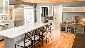 A modern kitchen with a central island, bar stools, and a built-in oven. - Grand Marais Retreat *Hot tub* (Grand Marais)