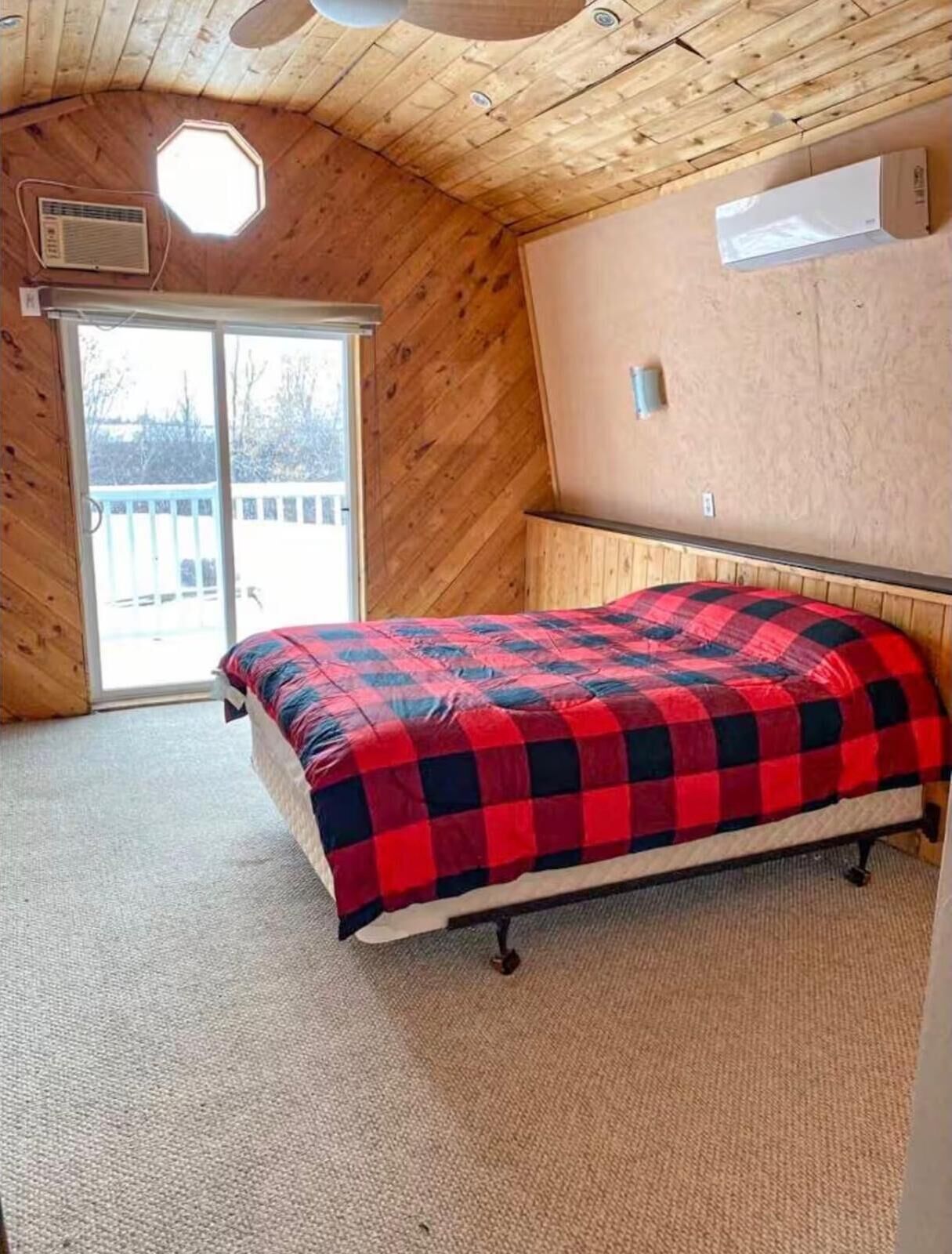 A bedroom with a bed, a window, and a ceiling fan.
