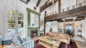 A cozy living room with a fireplace, a sofa, and a coffee table. - Olympic Valley Escape - Riverside Views + Hot Tub (Tahoe City)