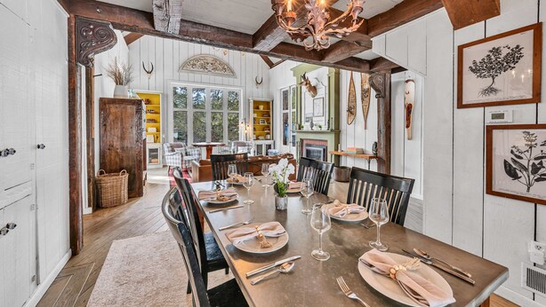 A dining room with a long table set for six, wooden beams on the ceiling, and a chandelier. - Olympic Valley Escape - Riverside Views + Hot Tub (Tahoe City)