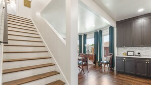 A staircase with wooden steps leading to a dining area with a table and chairs.