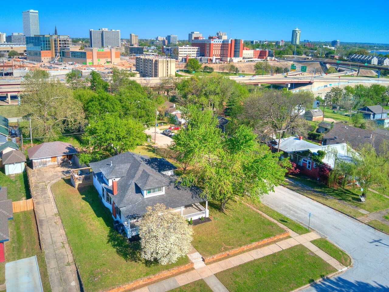 A residential area with houses, a road, and a city skyline in the background.