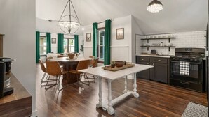 Een moderne keuken met donkere kastjes, een zwarte kookplaat en een witte betegelde achterwand.