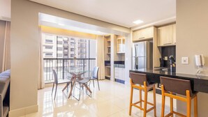 A modern kitchen with a large island, built-in cabinets, and a view of the city through large windows. - Condominium W/pool in a Prime Location in Jardim Goias - Wsls (Goiânia)
