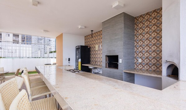 A modern kitchen with a marble countertop, a built-in oven, and a patterned backsplash. - Condominium W/pool in a Prime Location in Jardim Goias - Wsls (Goiânia)