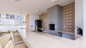 A modern kitchen with a marble countertop, a built-in oven, and a patterned backsplash.
