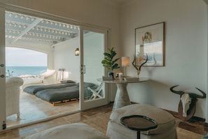 Una habitación con una cama, una mesa con una lámpara, una planta y una decoración con cráneo de toro.