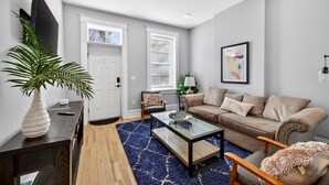 A living room with a sofa, coffee table, and a potted plant. - 7Br Group Haven: Yard • Fire Pit • 3 Kitchen (St. Louis)