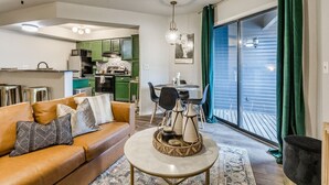 Una sala de estar con un sofá, una mesa redonda de centro y un comedor con sillas y una mesa.