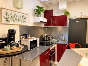A compact kitchen with a microwave, toaster, and coffee maker on the counter. - Cosy Large Apartment for 6 Guests in the Heart of Blois (Blois)