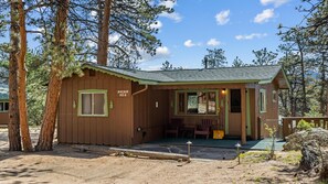 A small cabin with a porch, a window, and a door.