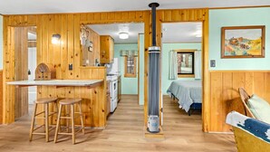 A wooden interior with a kitchen, bar area, and a bed. - Machin's Cottage #7 is calling! Pet Friendly (Estes Park)