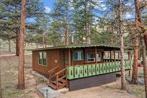 A cabin with a porch, a staircase, and a sign reading 'RACINE NO. 3'.