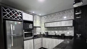 Uma cozinha moderna com frigorífico, forno e micro-ondas embutidos.