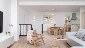 A spacious living area with a sofa, a dining table with chairs, a small side table, and a TV mounted on the wall. - Beautiful home in Seline (Seline)