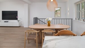 A modern dining area with a marble table, wooden chairs, and a hanging light fixture. - Beautiful home in Seline (Seline)