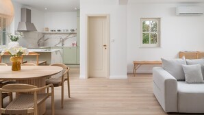 A modern living room with a grey sofa, a dining table with chairs, and a kitchen in the background. - Beautiful home in Seline (Seline)