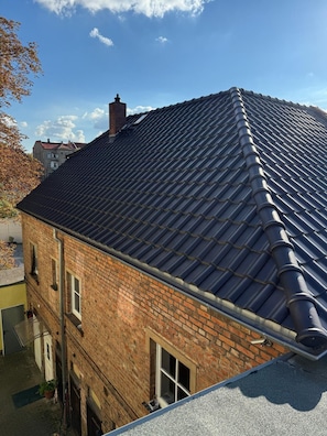 Ein Gebäude mit Satteldach, Backsteinwänden und einem sichtbaren Schornstein.
