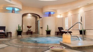 A spa area with a hot tub, lounge chairs, and potted plants. - Beachfront 1BR Suite at Villa del Palmar Flamingos - Pools, Spa & Sunsets (Nuevo Vallarta)