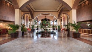 A spacious lobby with high ceilings, arched columns, and a central decorative fountain. - Beachfront 1BR Suite at Villa del Palmar Flamingos - Pools, Spa & Sunsets (Nuevo Vallarta)